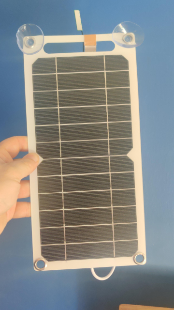 The front of the solar panel. The world's least good antenna can be seen poking from the top. There are suction cups to allow it to be attached to a window.
