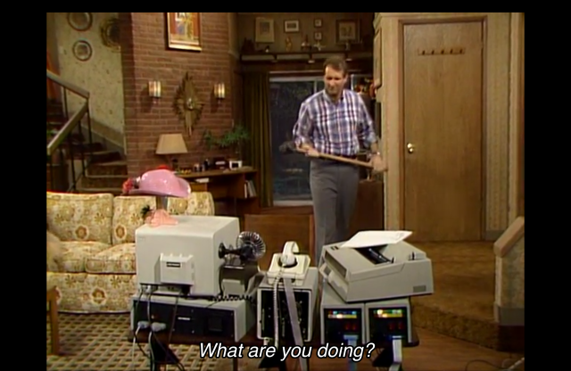 Al Bundy from Married with Children carrying a sledgehammer to a computer (with 3600 baud modem, VGA colour monitor, 40MB hard disk, and 7MB RAM. Yes, 7.) The computers voice in Al;s head is asking "What are you doing" after taunting him about it being a waste of money.