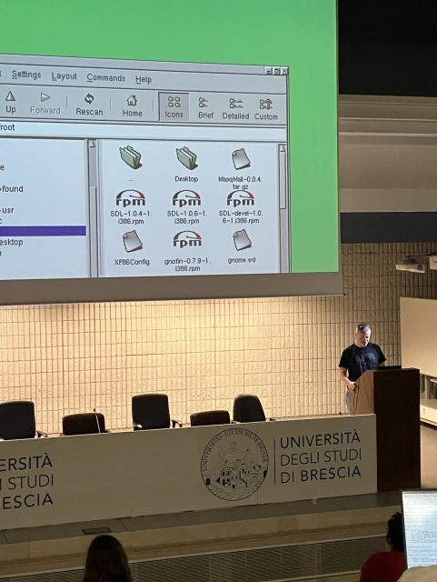 Jakub showing a screenshot of GNOME 1.x on stage at GUADEC