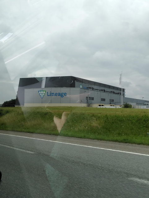 a gray building next to the highway that has a sign with "Lineage"