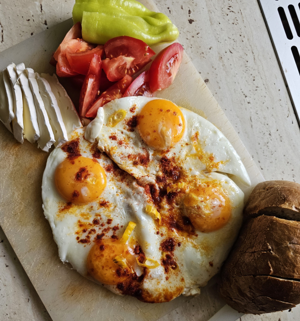 volské oká s paprikou rajčinou chlebom a hermelínom a bielej plastovej doske
