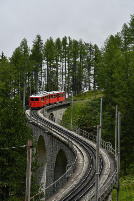 Ein roter Zug schlängelt sich übers Viadukt