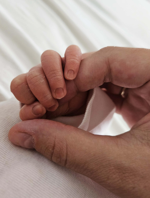 A little baby hand holding my fingers. 