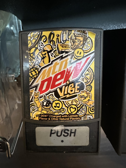 A yellow fountain drink dispenser labeled “Mtn Dew Vibe”