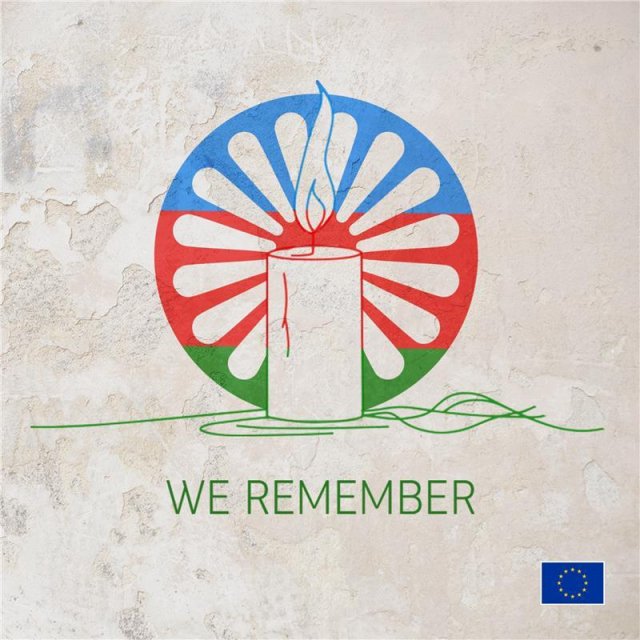 A line drawing of a candle with a flame, set against a circular background resembling the Romani flag, featuring red and blue colours with white segments radiating from the centre. Below the candle, it’s written 'WE REMEMBER'. The wall background in the image has a rough and weathered texture, with visible peeling paint and discoloration. It gives off a rustic appearance, suggesting age and wear. The EU flag in the bottom right corner. 