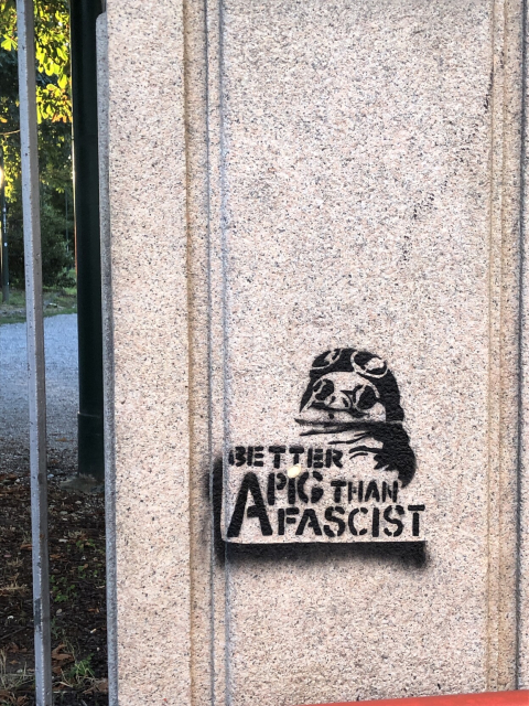 Stencil of Porco Rosso, with text "Better a pig than a fascist", spray painted on a wall.