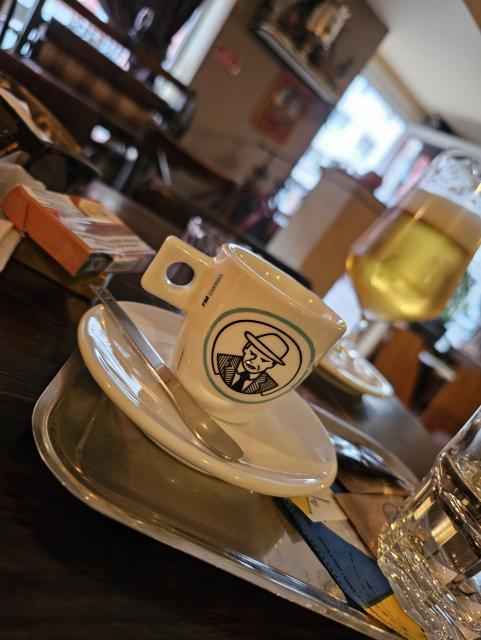 šálka s espressom a v pozadí polliter piva