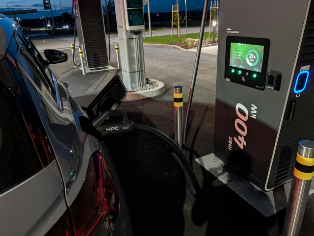 A close look at a 400 kW charger and a car being plugged in.