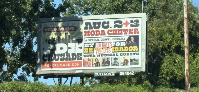 A photo of a billboard in Portland advertising an event called "PDX Crusade". The words "GOD HATES FASCISTS" has been affixed to the billboard.