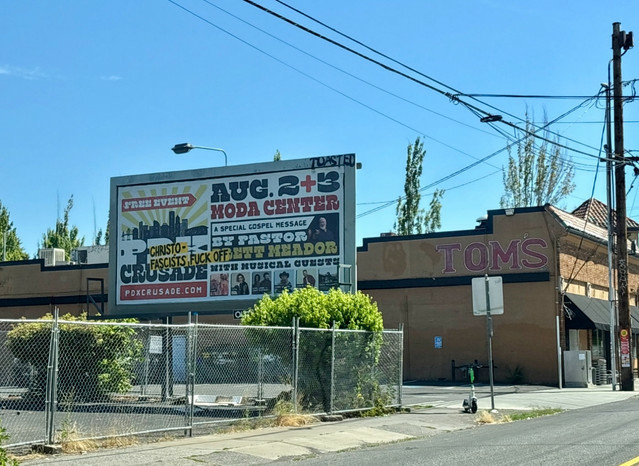 A photo of a billboard advertising an event called "PDX Crusade". The words "CHRISTOFASCISTS FUCK OFF" have been affixed to the billboard.