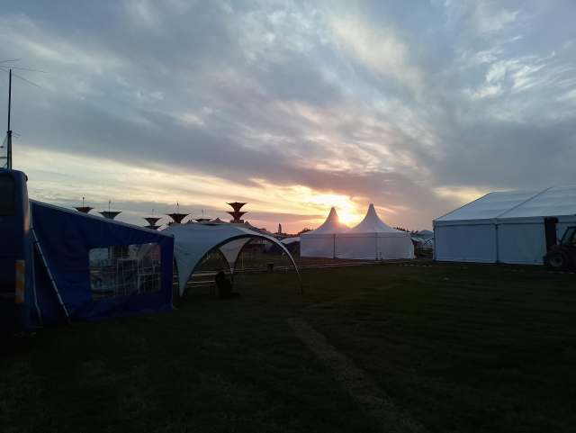 The sun setting over many tents