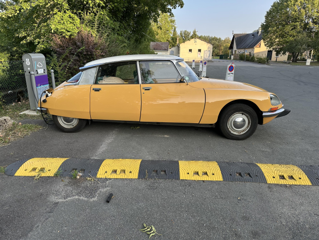 Yellow and white Citroen DS plugged into a public charger