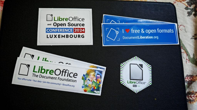 Four LibreOffice stickers including 'LibreOffice and Open Source Conference 2024 Luxembourg', 'I love free & open formats DocumentLiberation.org', 'LibreOffice The Document Foundation' with office icons, and a hexagonal LibreOffice logo