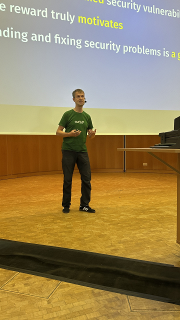 Daniel in a green curl shirt in front of his slides