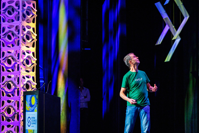 Daniel on stage looking up, backwards, presumable at the huge screen