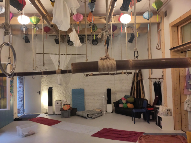 Photo of Karada House main room showing many hard points and bamboos hanging from the ceiling.

There's a path of towels laid through the room.