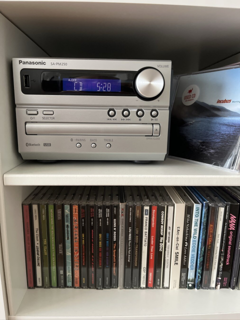 Panasonic CD player inside a shelf surrounded by CDs