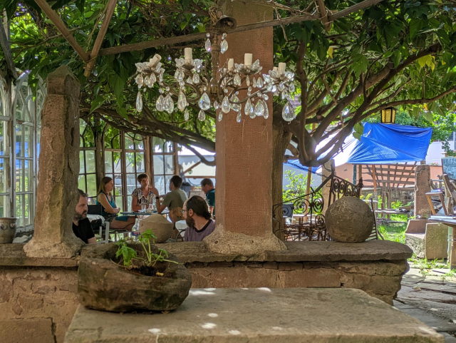 Repas sous l'arbre. Un lustre en premier plan.
