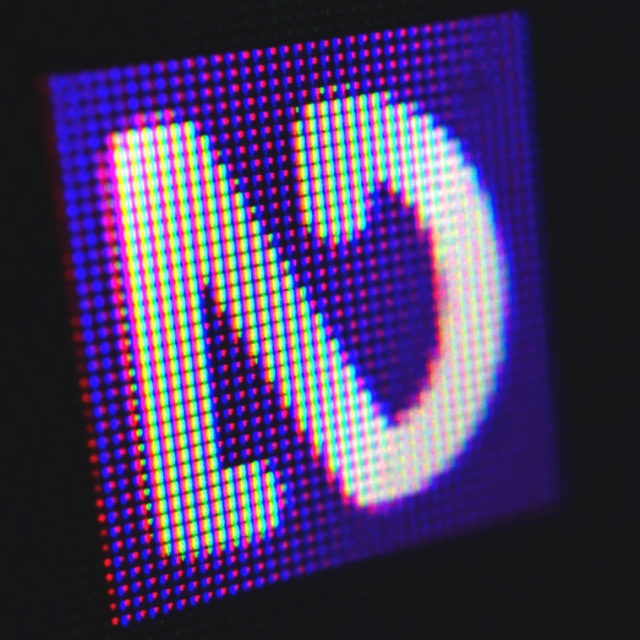 Close up of purple and white NVDA icon in the notification area with individual pixels visible