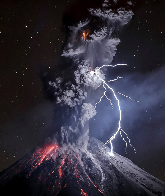 A volcano erupting at night with streams of glowing lava and a towering ash plume lit by a branching lightning bolt under a starry sky.