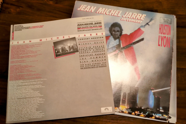 Album jacket and insert. On the cover, Jarre is wearing a pink jacket and has his keytar synth controller. In the background, Houston high rise buildings