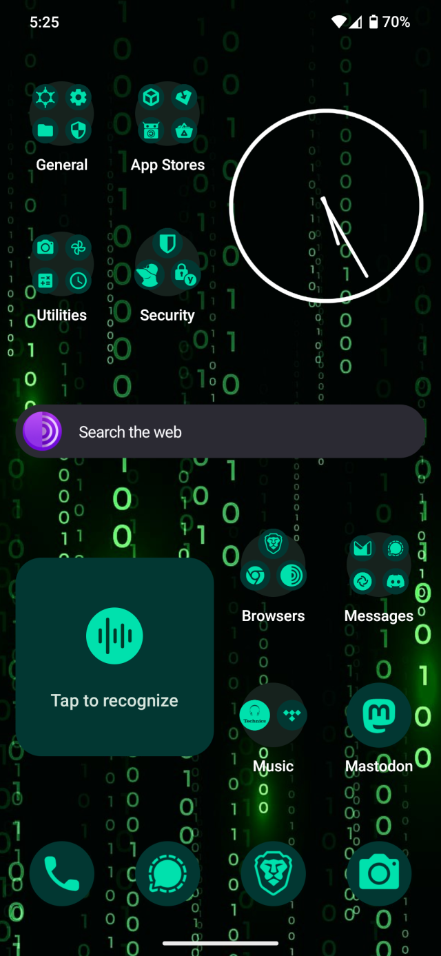 The GrapheneOS home screen. Dark wallpaper with green binary numbers. Green themed icons enabled. Apps organized in folders and widgets for a clock, Tor search, and Audile music recognition. The most significant apps visible on the screen for me are those from GrapheneOS, Obtainium, F-Droid, Aurora Store, Bitwarden, Yubico Authenticator, Mullvad VPN, Brave, Tor, Proton Mail, Signal, Element X, and Mastodon.