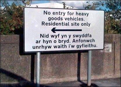 The picture is of a road sign. The top part is in English and the bottom part in Welsh.

The English part says, "No entry for heavy goods vehicles. Residential site only."
