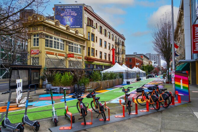 War zone in Portland, terrorist scooters and bikes lined up infront of terrorist gay flag mailbox 