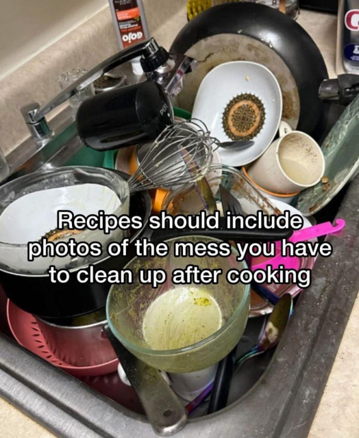 A stainless steel kitchen sink is overflowing with a large pile of dirty dishes, including a frying pan, bowls, plates, a whisk, and mugs. White text overlaid on the image reads, "Recipes should include photos of the mess you have to clean up after cooking."