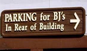 Sign reads “Parking for BJ’s in rear of building.”