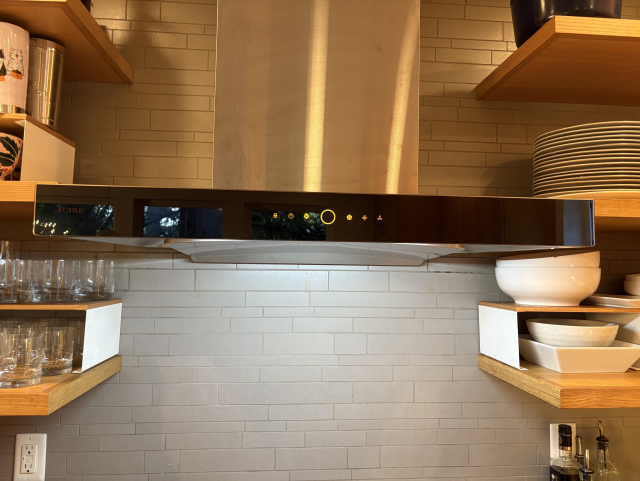 New Fotile vent hood installed next to oak floating shelves. 