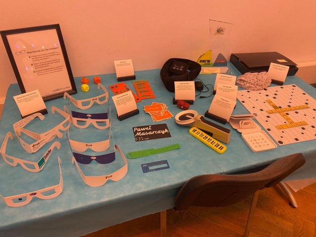 A table presenting different things to try out such as Braille Scrabble, vision impairment glassed and 3D printed interfaces and tactile tools.