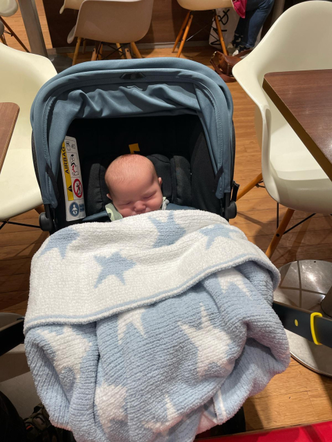 Baby Bertie snuggled in a blanket in his cool pushchair that turns into a car seat.