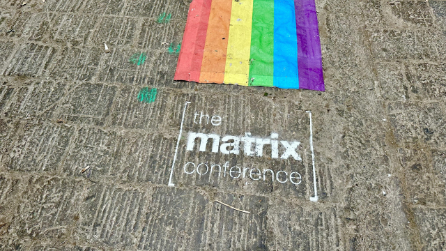 matrix conference sign on ground with rainbow flag