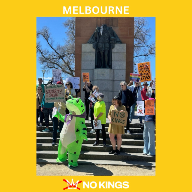 A photo of over a dozen people standing on steps at the No Kings protest in Melbourne, Australia. There are multiple “NO KINGS” signs and a person in a frog costume is at the front of the protest.