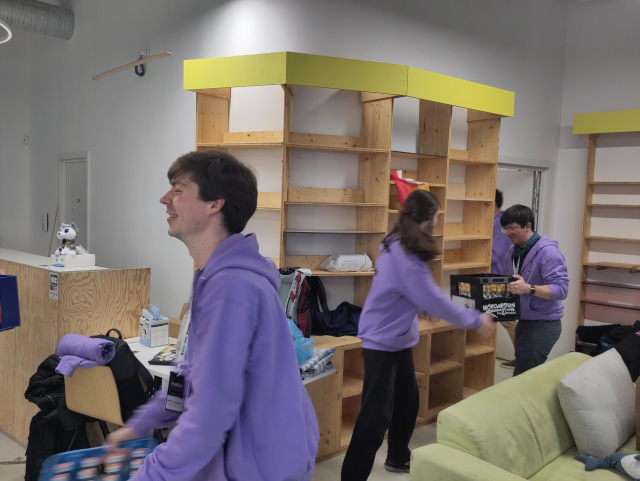 A human chain of volunteers unloading empty bottle crates of Riegele Spezi, Flora Mate, and more from the storage room.