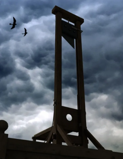 An ominous looking guillotine on a blustery day. Two ravens are flying by. 

 the-guillotine-large – History of Sorts
dirkdeklein.net
