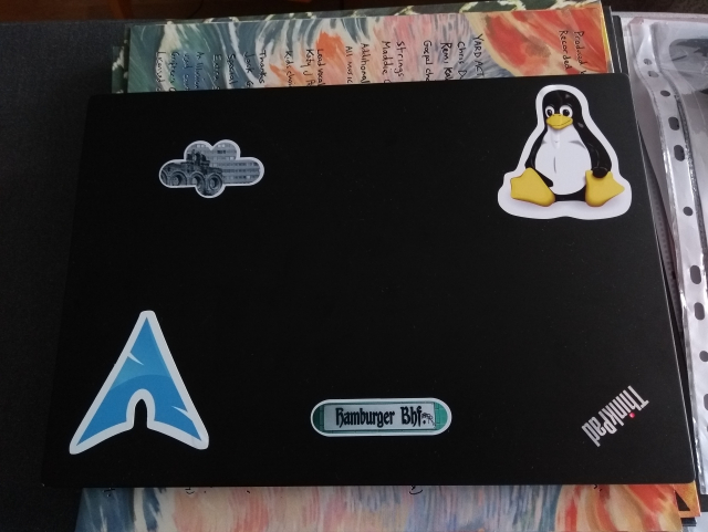 Black ThinkPad laptop with Linux and Berlin stickers.