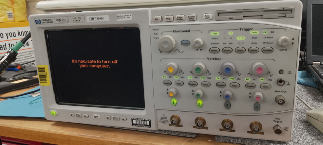 A HP Infiniium oscilloscope showing a Windows 95 "It's now safe to turn off your computer" screen.