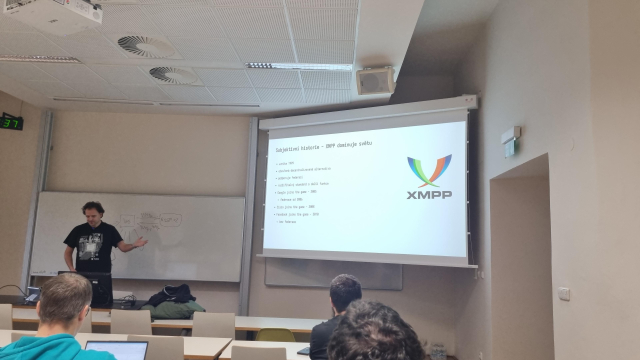 A white male in front of a screen with XMPP written on it.