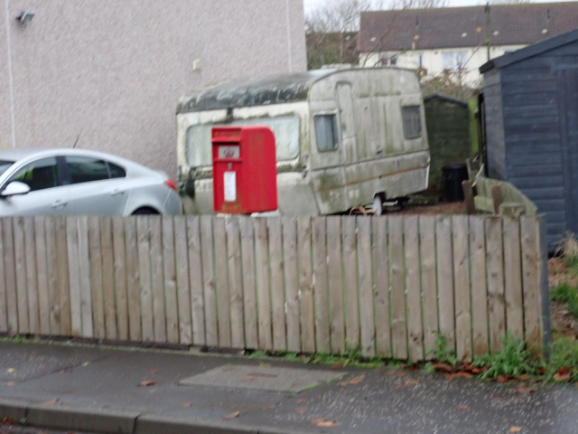 Fuzzy photo of a modern lamp post box. A Scottish Crown decal above the aperture can just about be recognised.