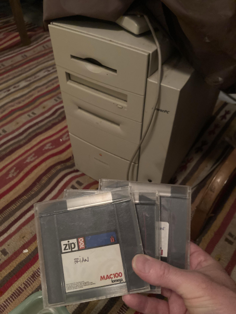 Old g3 power Mac and I’m holding 3 old Zip disks in front of it. 