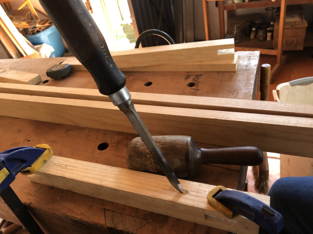 Un escoplo empezando a escarbar una caja en una de las patas del zapatero.