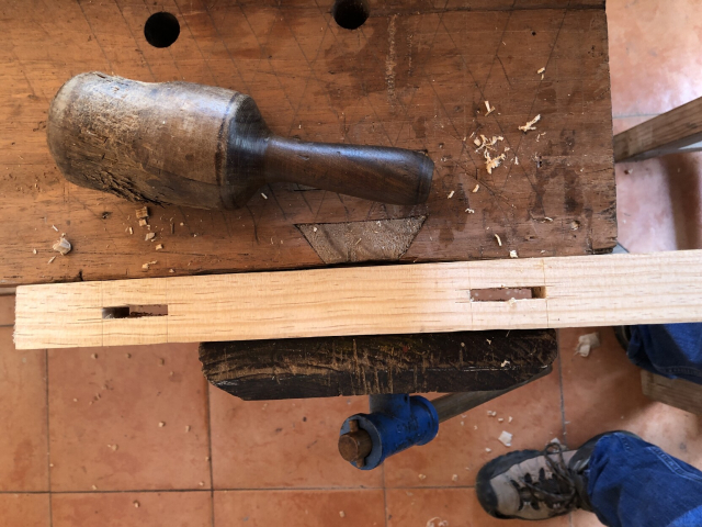 Dos cajas de 1/4" de ancho, que atraviesan una de las patas cuadradas del zapatero. Se ve el mazo de madera para el escoplo, uno de esos macitos redondos que hacen de guayacán en Yucatán.