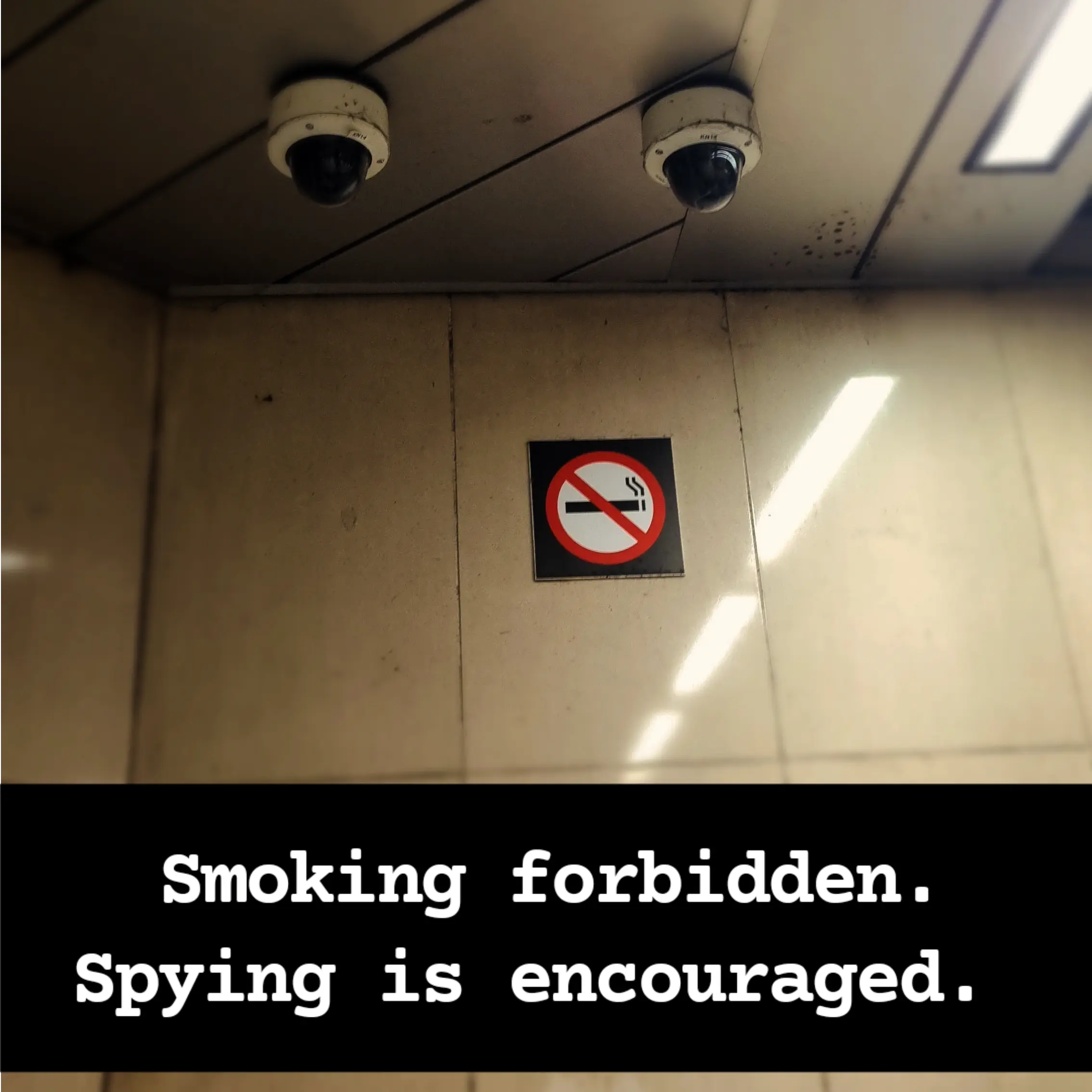 Two cameras and a sign smoking forbidden