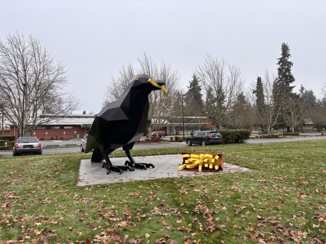 A giant statue of a crow eating French fries 