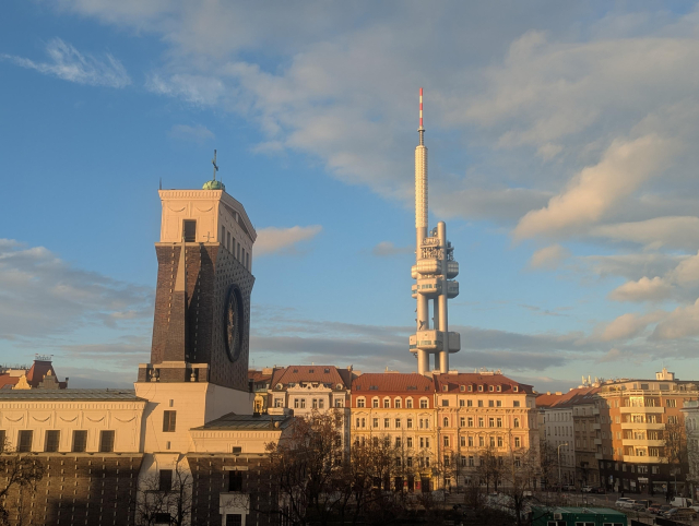 A view with a TV tower and a church in an orange sunset.