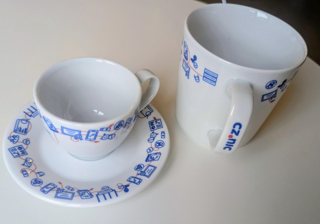 A porcelain cup with blue and red print and logo of CZ.NIC