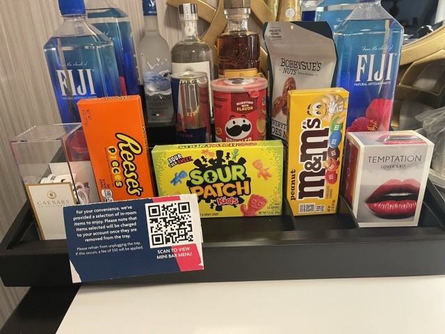 A hotel minibar tray warning that you will be charged if you remove any item or power off the tray