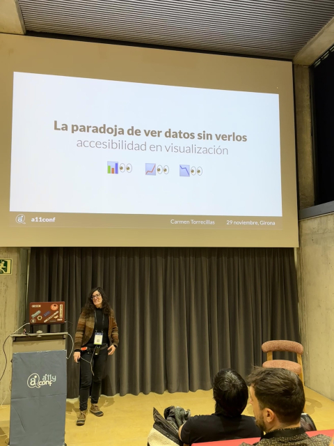 Carmen Torrecillas en el escenario del auditorio de la a11yConf 2025 en Gerona hablando de visualizacion de datos accesible delante de la audiencia